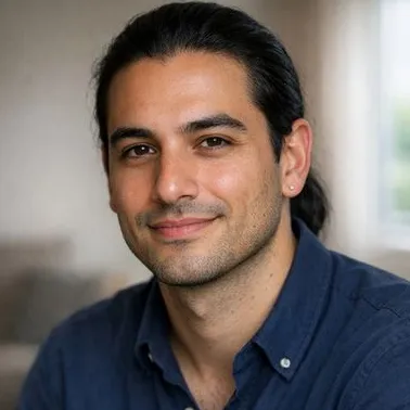 Young man, olive skin, black hair in low ponytail, calm expression